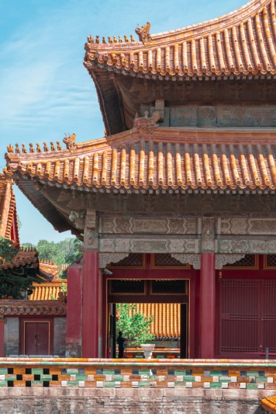 The red and green walls of the Forbidden City, adorned with glazed tiles and a yellow roof.