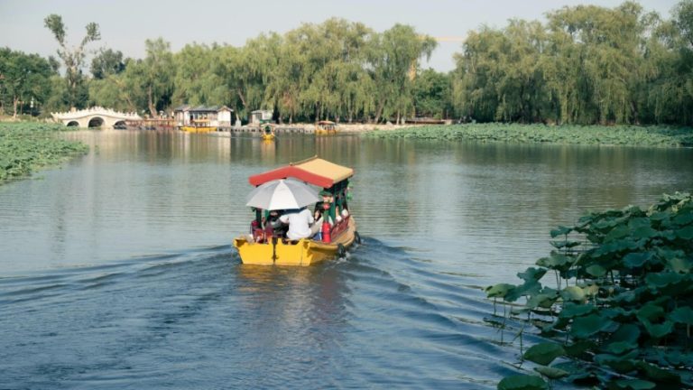 Tourists are enjoying a boat ride in yellow boats on the Fuhai Lake in the Old Summer Palace.