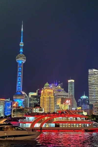 At night, the cruise boats along the Bund in Shanghai light up with colorful lights.