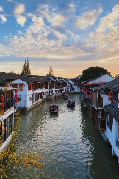 Tourists leisurely cruise along the river in Zhouzhuang Ancient Town, enjoying the sights from their boats.