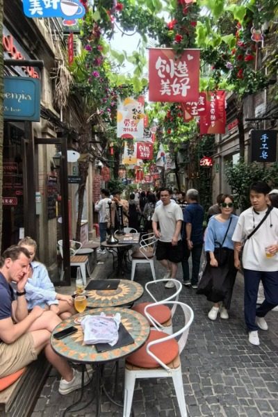 Many foreign tourists are enjoying coffee at Tianzifang in Shanghai.