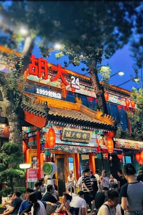 Tourists are lined up outside restaurants on Guijie Street to enjoy Beijing cuisine.