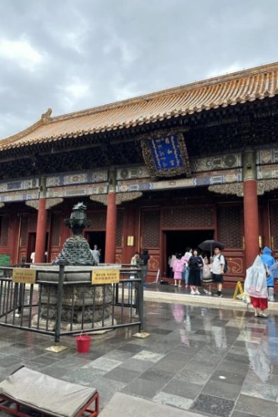 Tourists taking shelter from the rain under the eaves of Yonghe Temple.