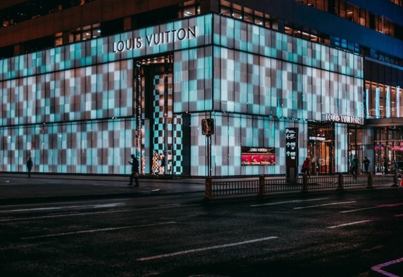 A large Louis Vuitton boutique with a blue LED exterior.