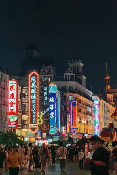 At night, the colorful lights of shop signs illuminate Nanjing Road Pedestrian Street in Shanghai.