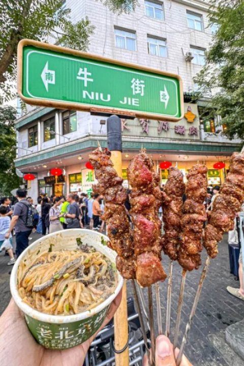 Tourists bought lamb skewers and noodles on Niujie Street in Beijing.