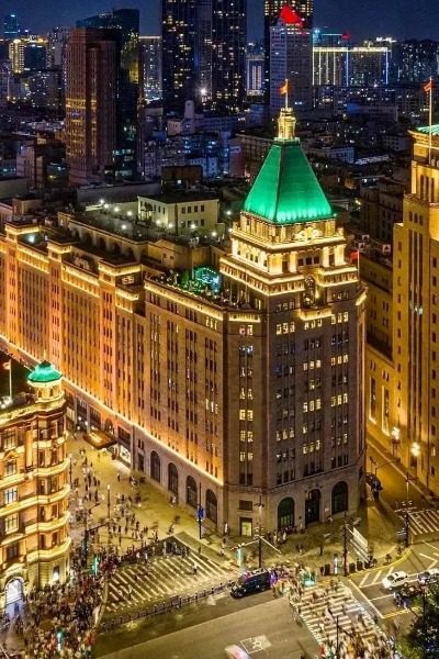 At night, the Peace Hotel in Shanghai shines brilliantly under the golden lights.