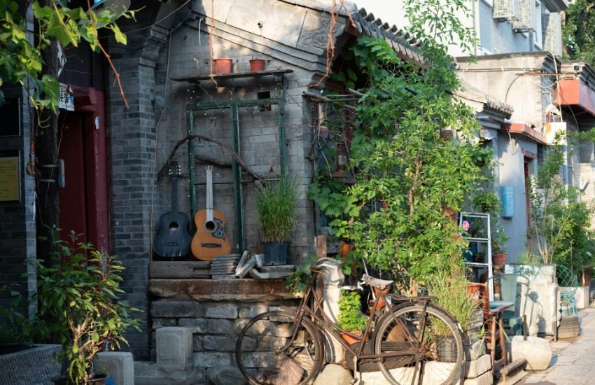 At the entrance of a Beijing courtyard, there’s a bicycle and two guitars displayed.