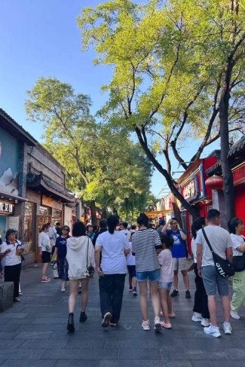 The bustling crowds of tourists are happily strolling through Nanluoguxiang.