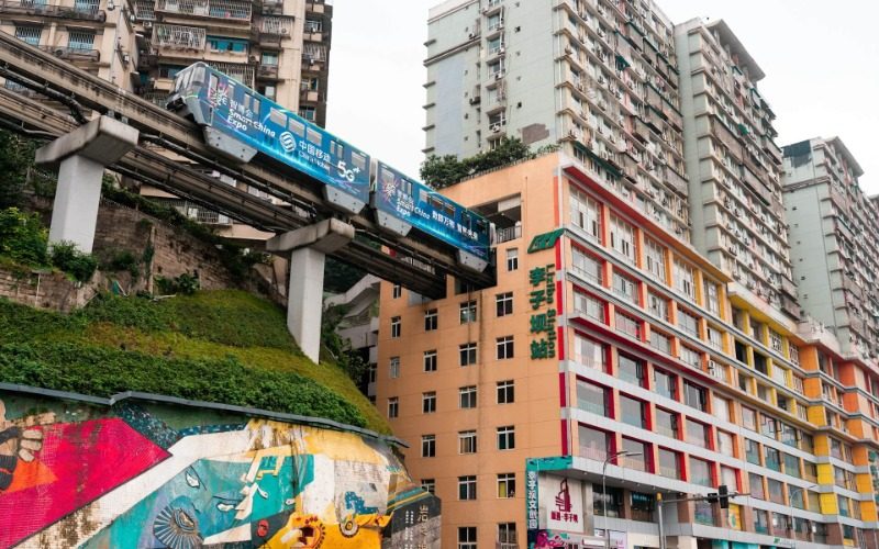 The scene of trains passing through residential buildings at Liziba Metro Station in Chongqing.