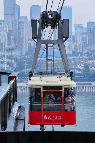 The Yangtze River Cableway that the tourists are riding is about to arrive at the station.