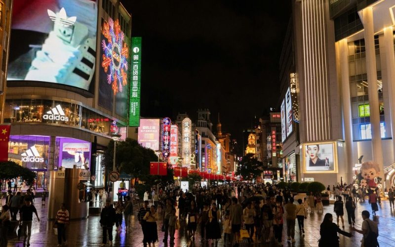 There are many travelers exploring Nanjing Road Pedestrian Street in Shanghai.