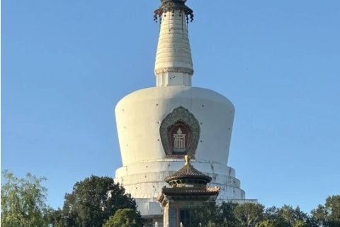 The White Pagoda in Beihai Park resembles a white bottle, surrounded by lush trees.