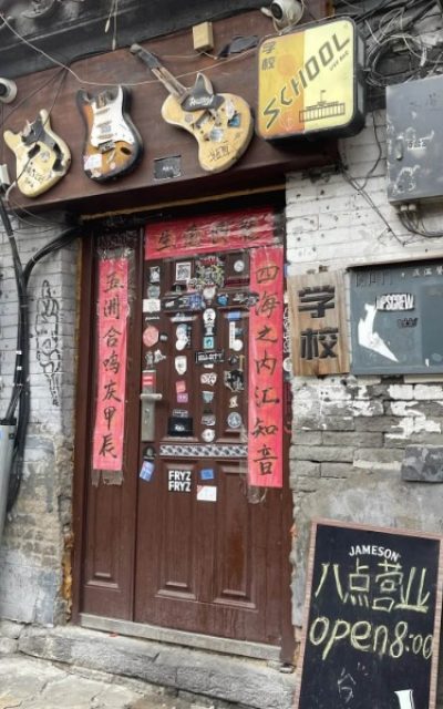 A unique door in a Beijing hutong, with three guitars hanging on it.