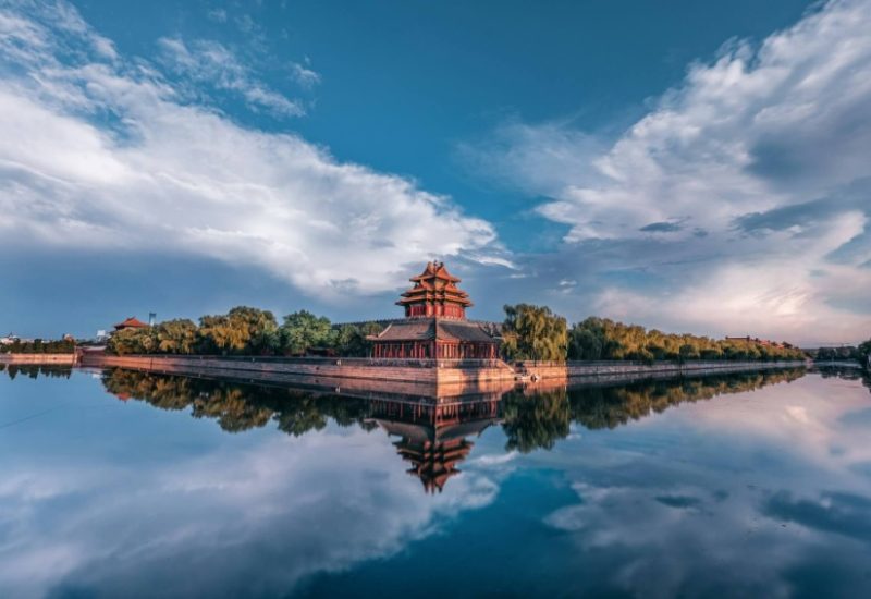 The bright blue sky reflects in the moat outside the Forbidden City.