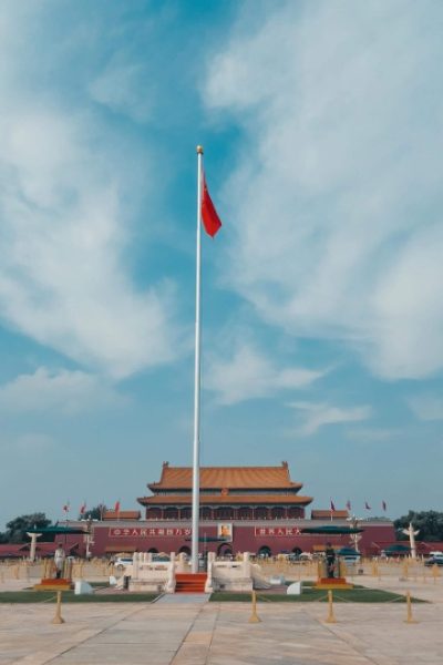 The five-star red flag of China flutters in the wind atop the flagpole at Tiananmen.