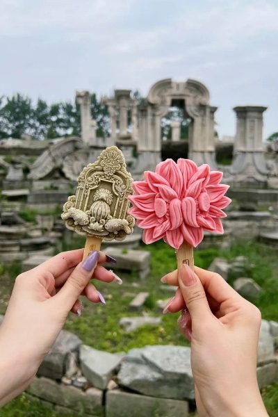 Tourists are holding up ice cream shaped like the Dashuifa for a photo.