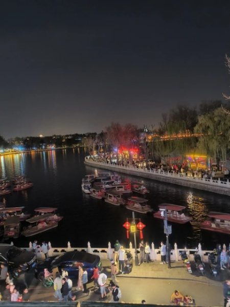 Many tourists are strolling along the bar street by Houhai at night.